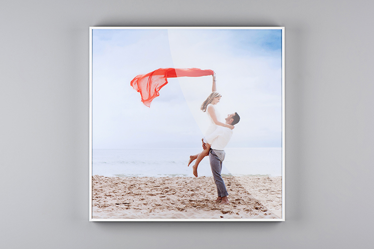 Custom photo wall art of a white perspex box frame of a couple on the beach with a red scarf